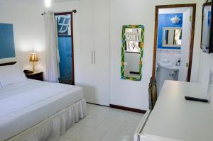 1 dormitorio con cama, lavabo y espejo en Guest House Green Garden, en Búzios