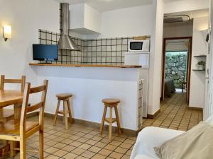 a kitchen with a table and stools in a room at Apartamento La Palmera Plaza in Sant Martí d’Empúries
