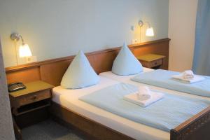 a room with two beds with towels on them at Hotel Simonis Koblenz in Koblenz