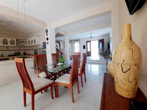 a dining room with a table and chairs and a vase at Casa Quintal - Cerca del mar in Cancún