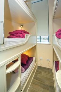 a bedroom with two beds and a dresser at Canolfan Y Fron in Caernarfon