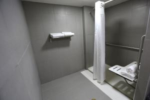 ein Bad mit einer Dusche, einem WC und Handtüchern in der Unterkunft Holiday Inn O'Hare Area, an IHG Hotel in Rosemont