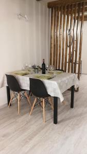 einem Esstisch mit 2 Stühlen und einem Tisch mit Gläsern in der Unterkunft Cesare Home in Palermo