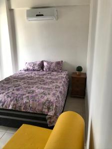 ein Schlafzimmer mit einem Bett und einem gelben Stuhl in der Unterkunft Casa paraíso 2 in Arraial do Cabo