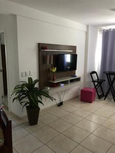 a living room with a flat screen tv on a wall at Casa paraíso 2 in Arraial do Cabo