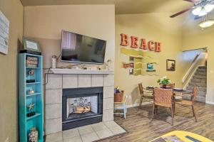 a living room with a fireplace and a television on a wall at Romantic Galveston Retreat Bay View, Pool Access! in Galveston