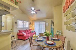 a living room with a table and a red couch at Romantic Galveston Retreat Bay View, Pool Access! in Galveston