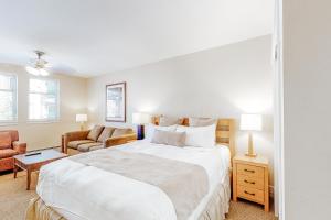 biała sypialnia z dużym łóżkiem i krzesłem w obiekcie Founders Pointe Condo w mieście Winter Park