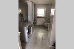 a bathroom with a washing machine and a sink at room for four in Alzenau in Unterfranken