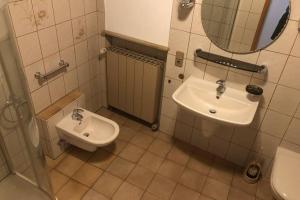 a bathroom with a sink and a toilet and a mirror at room for four in Alzenau in Unterfranken