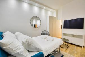 um quarto com uma cama com almofadas brancas e uma televisão em Luxury home in heart of PARIS!Opera/Eurostar 6pers em Paris