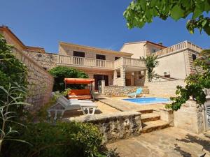 a villa with a swimming pool and a house at Holiday Apartement Marija Supetar with private pool in Supetar