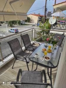 a table and chairs on a balcony with food on it at Blue North Luxury Apartment in Limenas