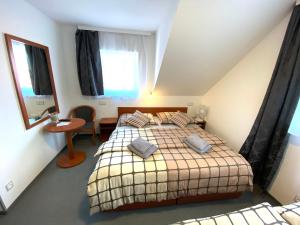 Schlafzimmer mit einem Bett, einem Tisch und einem Fenster in der Unterkunft Penzion Hornička in Český Krumlov