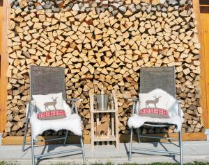 two chairs in front of a wall of logs at Chalex in Aigen im Mühlkreis