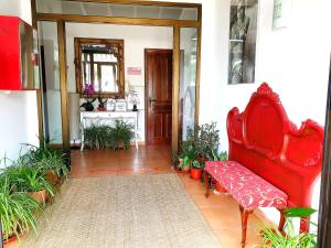 eine rote Bank in einem Raum mit Pflanzen in der Unterkunft El Rincón de la ESPE in Albalate de Zorita