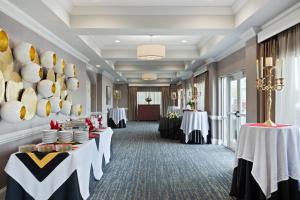 a banquet room with two tables with white and black table settings at Holiday Inn Valdosta Conference Center by IHG in Valdosta