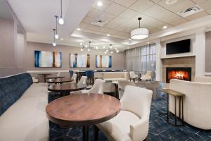 a restaurant with tables and chairs and a fireplace at Holiday Inn Valdosta Conference Center by IHG in Valdosta