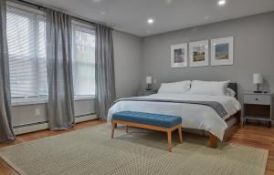een slaapkamer met een groot bed en een blauwe kruk bij Holly Lodge - Ski Windham Hunter Catskills in Prattsville