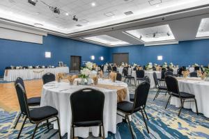 um salão de banquetes com mesas e cadeiras numa sala em Holiday Inn Melbourne-Viera Conference Ctr, an IHG Hotel em Melbourne