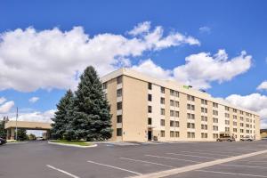 ein großes Gebäude mit einem Parkplatz davor in der Unterkunft Ramada Plaza by Wyndham Sheridan Hotel & Convention Center in Sheridan