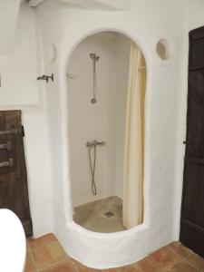 a bathroom with a tub with a shower curtain at Casa La Romanilla in Capileira