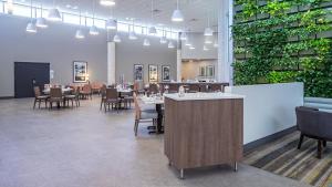 a dining room with tables and chairs and plants at Holiday Inn Panama City by IHG in Panama City