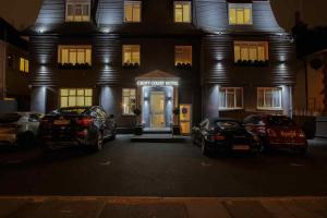 two cars parked in front of a building at night at Croft Court Hotel in London