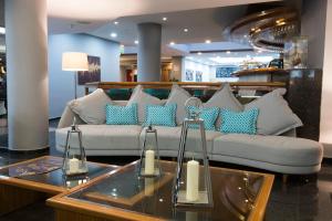 a living room with a couch with blue and white pillows at Holiday Inn Montevideo by IHG in Montevideo