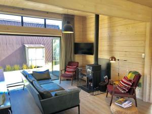 a living room with a couch and a fireplace at Modern Kowhai Cottage in Wanaka