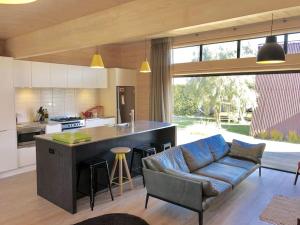 a living room with a blue couch in a kitchen at Modern Kowhai Cottage in Wanaka