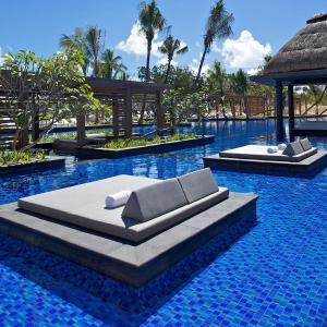 a swimming pool with two beds in a resort at Long Beach Mauritius in Belle Mare