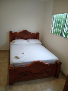 a bedroom with a wooden bed in a room with a window at CasaHotelMarly in Santa Marta