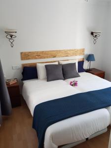 a bedroom with a large white bed with blue pillows at Avenue Puerto del Carmen in Puerto del Carmen