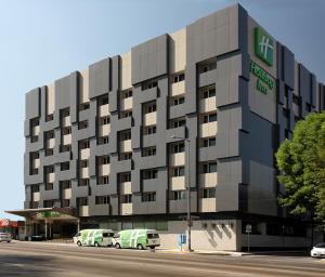 a building with cars parked in front of it at Holiday Inn Mexico City - Trade Center by IHG in Mexico City