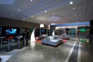 a living room with white furniture and a television at Holiday Inn Mexico City - Trade Center by IHG in Mexico City