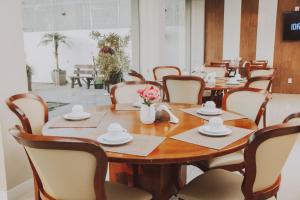 uma sala de jantar com uma mesa de madeira e cadeiras em Confort Fronteira Hotel em Santana do Livramento