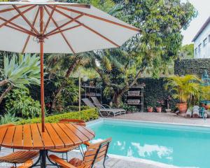 a table with an umbrella next to a swimming pool at Pousada Beco Do Bispo in São João del Rei
