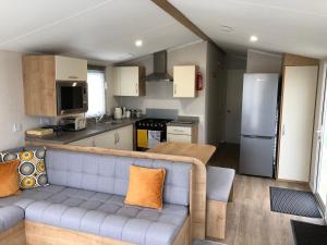 a living room with a couch and a kitchen at Whitley bay 4 berth Luxury Caravan in Newcastle upon Tyne