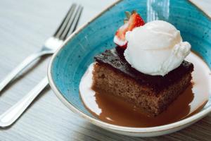 een stuk taart met ijs en een aardbei erop bij Holiday Inn Newcastle Gosforth Park by IHG in Newcastle upon Tyne