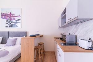 une chambre avec un lit et une cuisine avec un four micro-ondes dans l'établissement Jevrejska-Central Studio, à Novi Sad