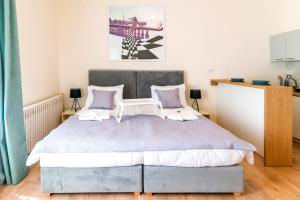 - une chambre avec un grand lit et des oreillers violets dans l'établissement Jevrejska-Central Studio, à Novi Sad