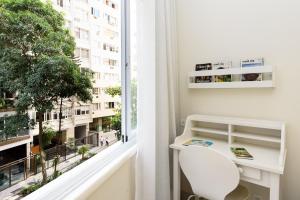 escritorio blanco y silla en una habitación con ventana en Refúgio em Copacabana - Perto da praia - DF219 Z3, en Río de Janeiro