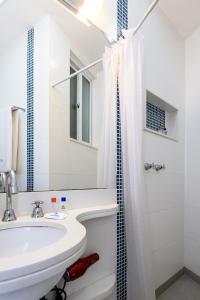 y baño blanco con lavabo y ducha. en Refúgio em Copacabana - Perto da praia - DF219 Z3, en Río de Janeiro