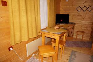 um quarto com uma mesa de madeira e uma secretária com uma televisão em Natura Chalets em Praid