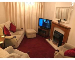 a living room with a fireplace and a television at 42 Beaumont Rise Rental - Worksop in Worksop
