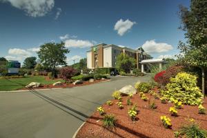 una carretera con un edificio y flores en un patio en Holiday Inn Express Hotel & Suites Middleboro Raynham, an IHG Hotel, en Middleboro