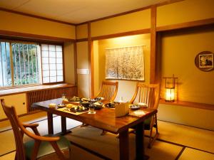 Sumiyosiya Ryokan في نوزاوا أونسن: غرفة طعام مع طاولة وكراسي خشبية