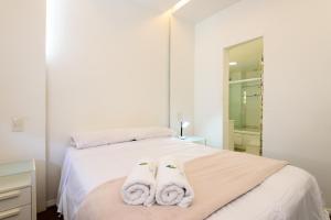 Un dormitorio con una cama blanca con toallas. en Excelente em Ipanema - Ambiente familiar - BT101 Z2, en Río de Janeiro