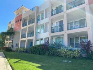 un gran edificio blanco con césped delante en Oceania Apartments at Arecibo 681 Ocean Drive, en Arecibo